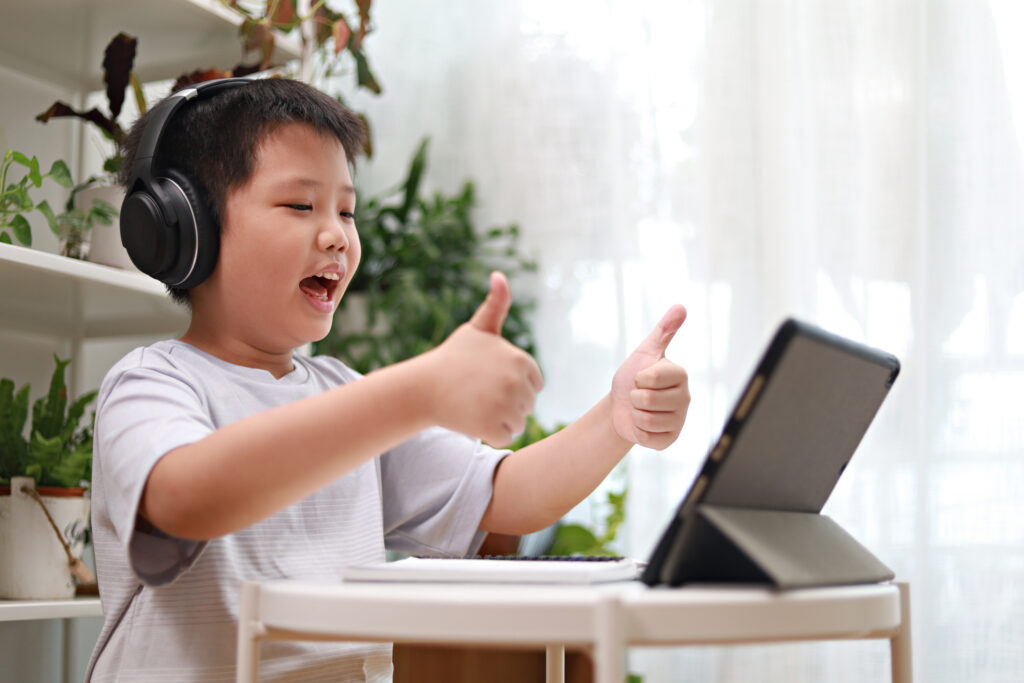 Motivierter Schüler gibt Daumen hoch bei den Sprachkurse am Tablet